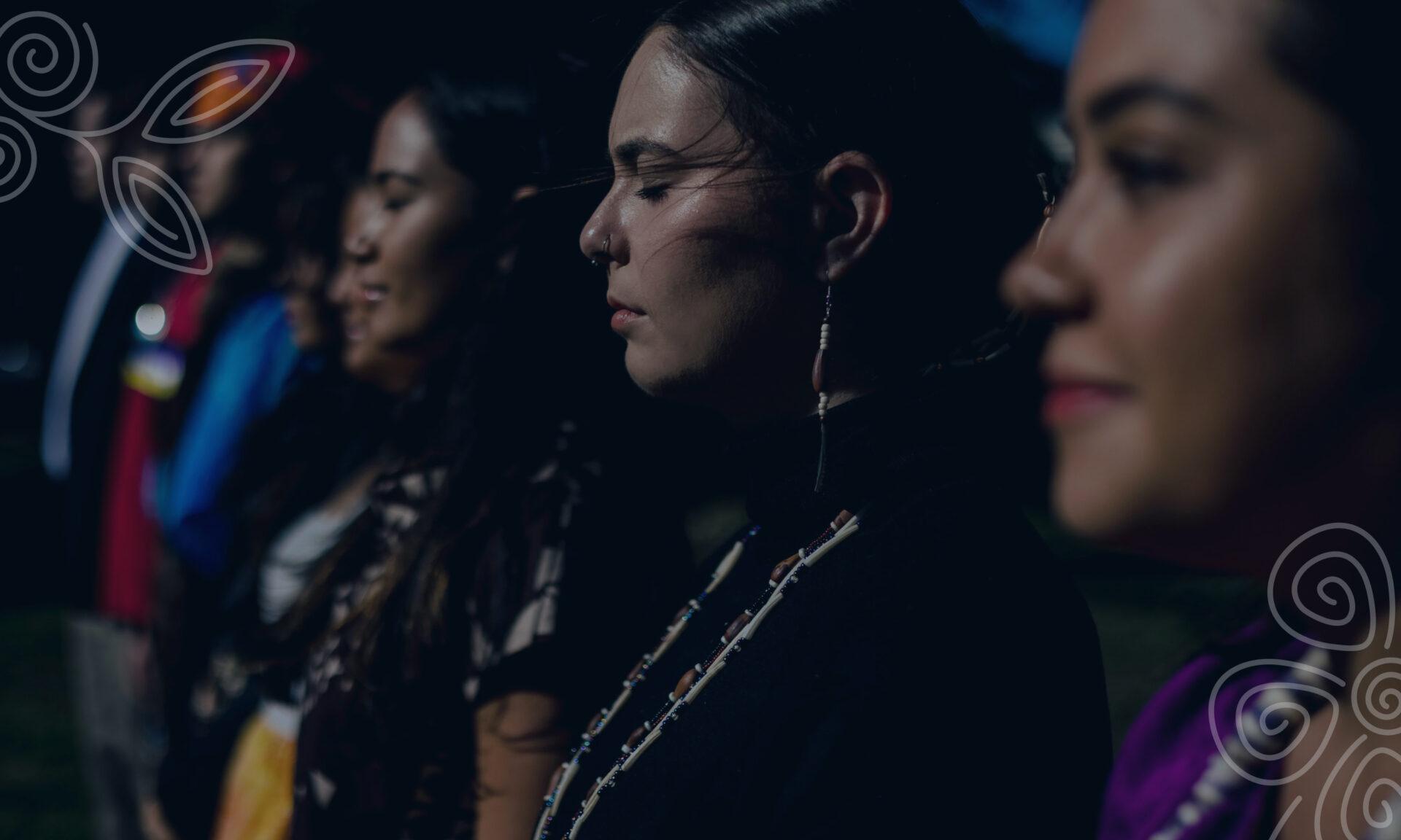Group of Native women standing together with looks of peace and resolve on their faces.