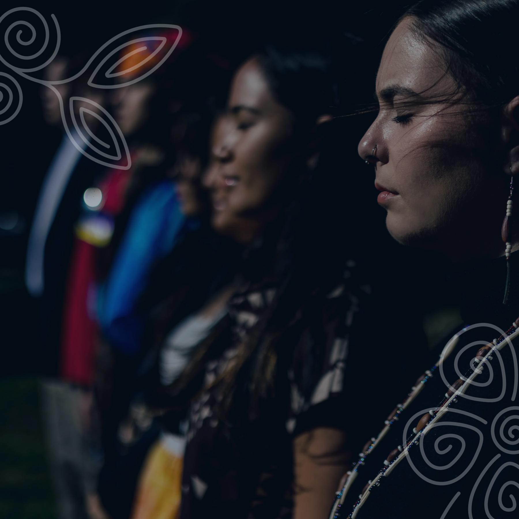 Group of Native women standing together with looks of peace and resolve on their faces.